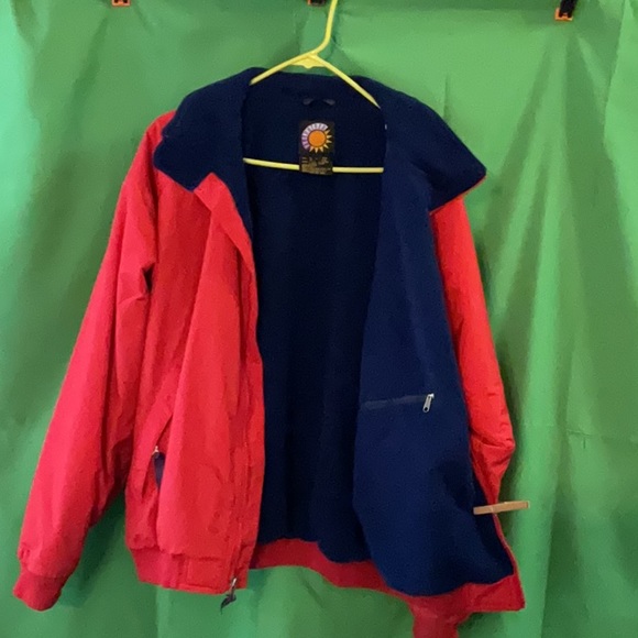 Bright red windbreaker with navy blue fleece lining and insulated sleeves. - Picture 2 of 11